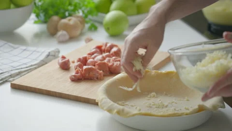 A man at home makes a deep dish pizza with cheese and sausages Stock Footage 219676042