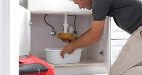Man At Home Mopping Up Water From Leaking Pipe in Bathroom Stock Footage 120670669