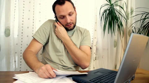 Man in home office with computer, phone and paperwork Stock Footage 1007345