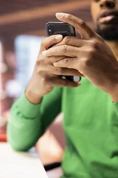 Man in home office using smartphone to compose social media posts Stock Photos