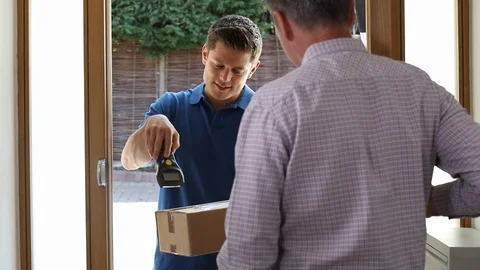 Man At Home Opens Door To Courier Delivering Package Stock Footage 93257192