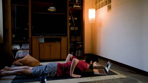 Man at home practicing physical activities through online instruction. Home w Stock Footage 130610790