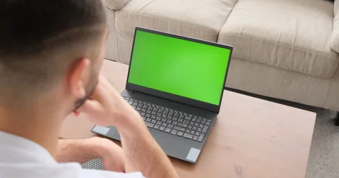 Man at home sitting on a sofa working on laptop computer 库存影片 150024524