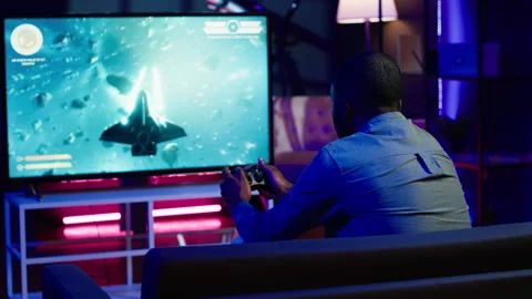 Man in home theatre using high tech gaming console gamepad Stock Footage 283144337