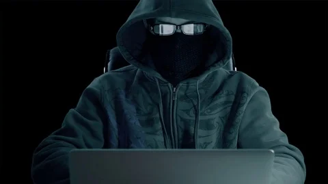 Man in hood sitting at table and coding on laptop. Front view close up. Hacker Stock Footage 82663878