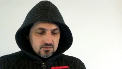 A man in a hood with a smartphone Stock Footage 93132420