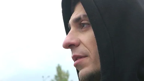 The man in the hood smokes a cigarette Stock Footage 75685764