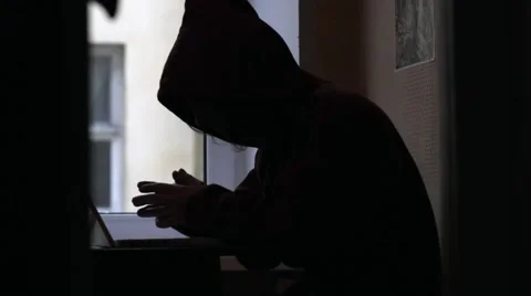 Man in hood typing on laptop Hacker Stock Footage 61009687