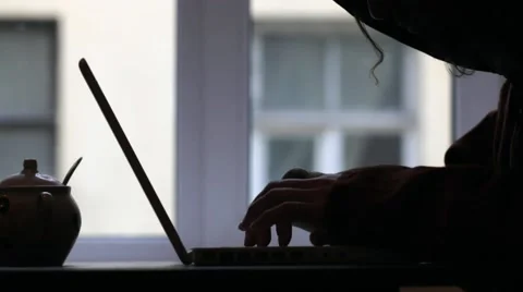 Man in hood typing on laptop Hacker Stock Footage 61009761