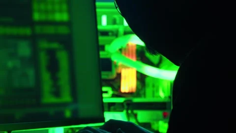 Man in a hoodie is hacking on a computer in a dark room. Stock Footage 279021100