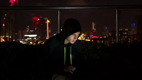 Man in hoodie hacking website at night Stock Footage 138719878