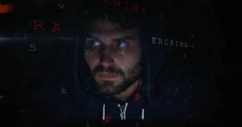Man in hoodie surrounded by digital code, focusing on cybersecurity tasks Stockfoto's