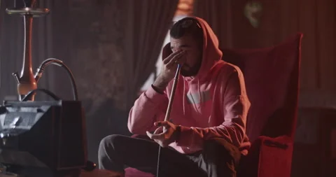 Man with hookah pausing videogame Stock Footage 229484635