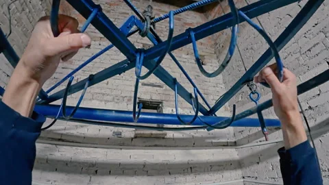 The man hooks his hands on the elevator and is lifted up by the mechanism. Stock Footage 313953191