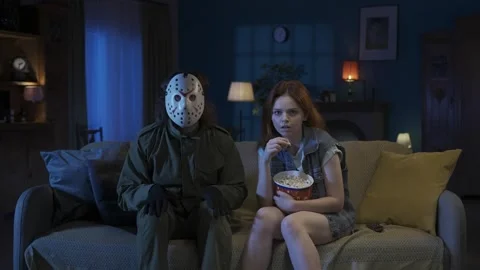 Man horror maniac sitting on the sofa with girl, watching movie, eating popcorn Stock Footage 250005675