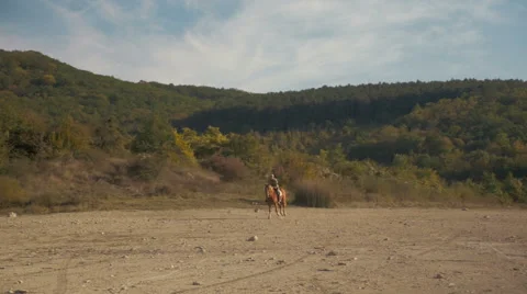 A man on a horse galloping in the mountains Stock Footage 63118981