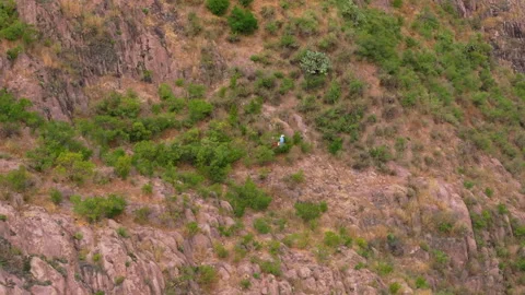 Man on Horse Navigates Difficult Rocky Cliff Edge at Height in Mountain Terrain. Stock Footage 337910917