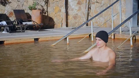 Man in hot spring geothermal pool Stock Footage 83465554