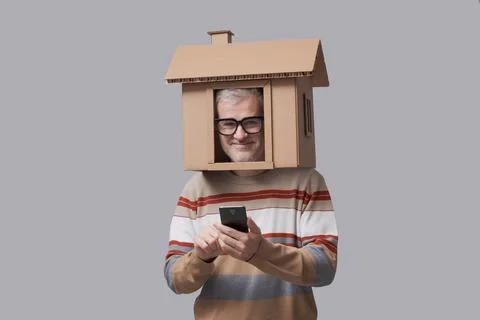 Man with house on his head using real estate apps Stock-Fotos