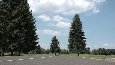 A man on a hoverboard passes by the camera on the road against the blue sky Stock Footage 100064426