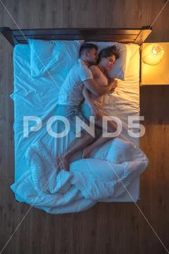 The man hug a woman on the bed. evening night time. view from above Stock Photos