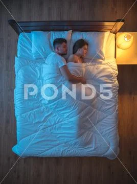 The man hug a woman on the bed. evening night time. view from above Stock Photos