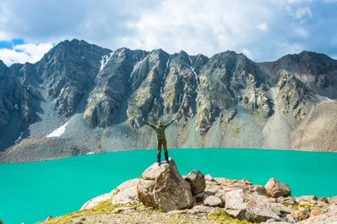 A man on a huge rock performs the asanas. Stock Photos