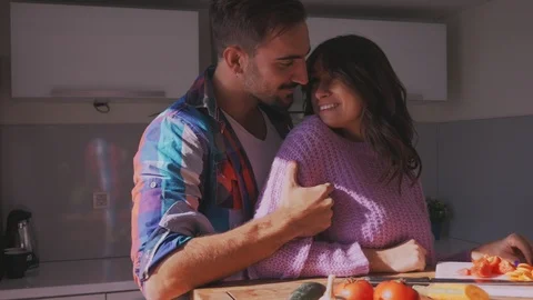 Man hugging and caressing girlfriend in the kitchen Stock Footage 97647796
