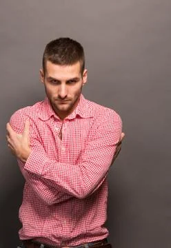 Man hugging himself in studio Stock Photos