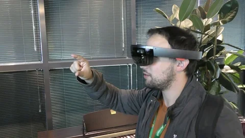 A man hunts bugs with Microsoft HoloLens, a self-contained holographic computer Stock Footage 70933575