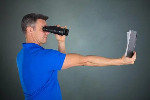 Man With Hyperopia Eye Disorder Reading A Book Using Binocular Stock Photos