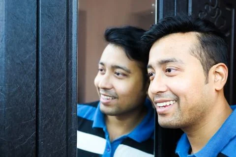 A man i and his reflection in mirror smiling in happy mood Stock Photos