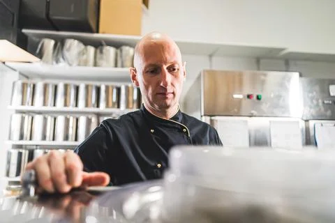 Man ice cream maker looking at the milk inside a pasteurizer in a production Stock Photos