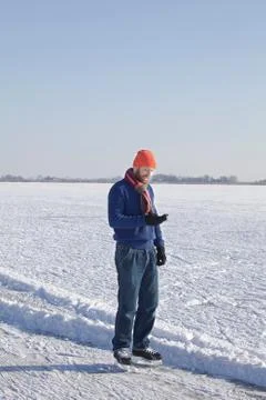 Man in ice skates using cell phone Stock Photos