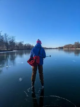 Man Ice Skating on Smooth Clear Black Ice at Toronto Island With a Selfie Sti Stockfoto's