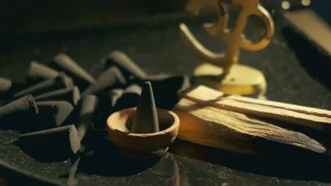 Man ignites a lighter triangular incense in a small stand Stock Footage 134828738