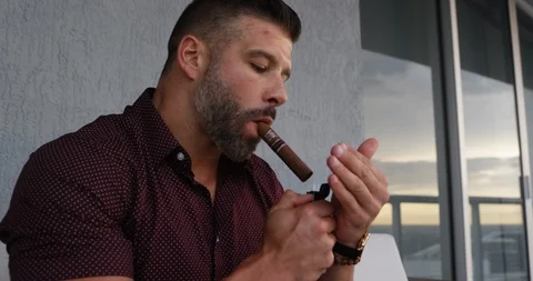 Man igniting cigar with lighter Stock Footage 116347420