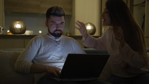 Man ignoring his wife while working on his laptop Video stock 100001593