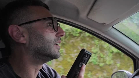 Man Ignoring Traffic Rules Recording Voice Note on Phone While Driving Stock Footage 335701887