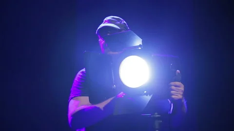 A man illuminator directs the light of a searchlight Stock Footage 106633087
