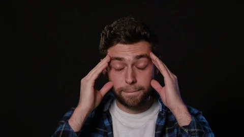 A Man Immitating Headache Against a Black Background Stock Footage 88439062
