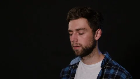 A Man Immitating Headache Against a Black Background Stock Footage 88440509