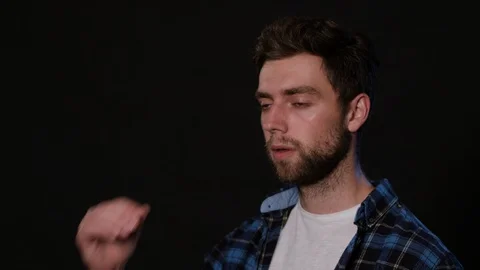 A Man Immitating Headache Against a Black Background Stock Footage 88441122