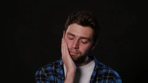 A Man Immitating Toothache Against a Black Background Stock Footage 88442165
