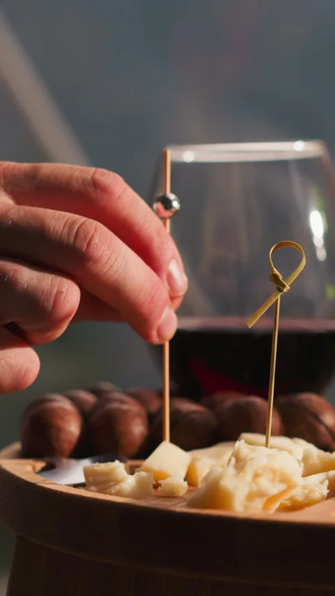 Man impales cheese onto skewer at small table Stock Footage 309834749