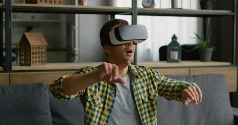 Man is impressed by 360 video concept, wearing vr headset at home Stock Footage 114889212