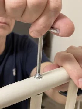 Man independently assembles a clothes hanger on wheels. Home improvement. Tools Stock Photos