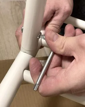 Man independently assembles a clothes hanger on wheels. Home improvement. Tools Stock Photos