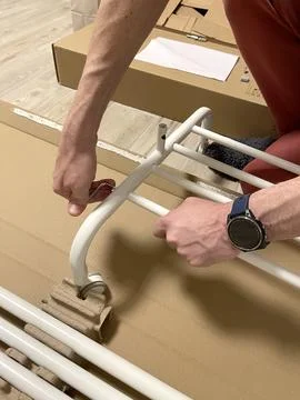 Man independently assembles a clothes hanger on wheels. Home improvement. Tools Fotos Stock