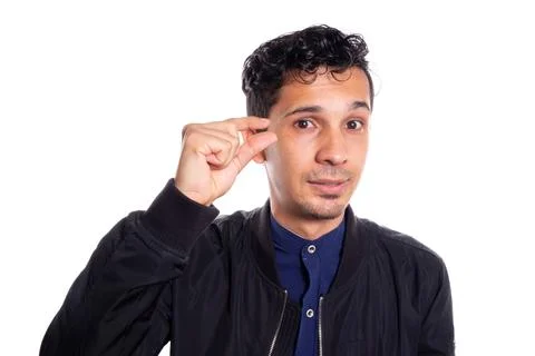 Man indicating that something is small, white background. Young adult indicating Stock Photos